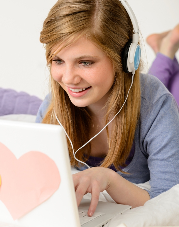 Young teenage girl chatting on laptop